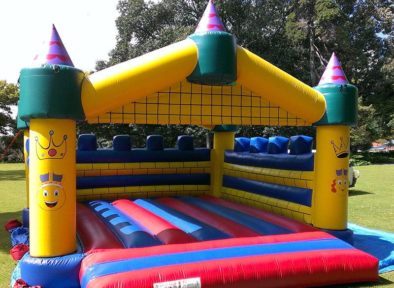 Yellow, Blue and Red Bouncy Castle Setup on Grass Oval
