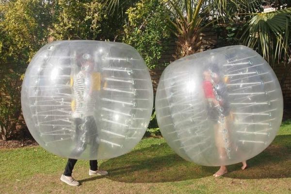 2 People Playing in Inflatable Zorb Balls on Grass