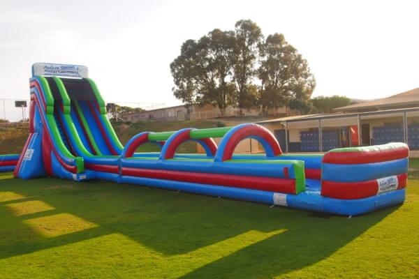Side View of 2 Lane Inflatable Mega Water Slide on Grass Oval
